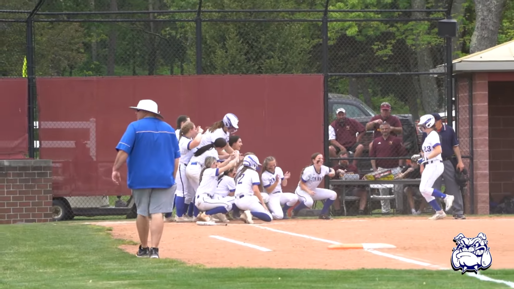 Team celebrating at home plate as mary is jogging to them